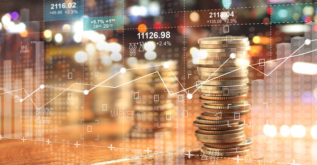 A stack of coins against a background of charts and figures